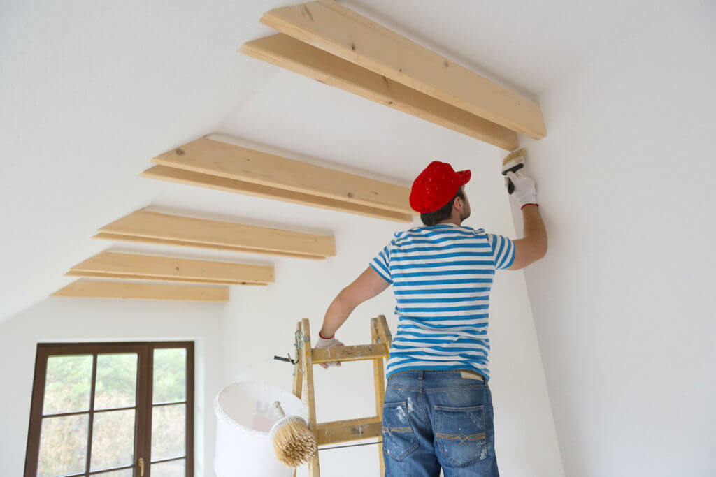 Professional painting service team applying fresh paint to residential home exterior